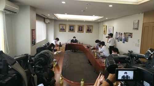 *記者会見で訃報を伝える青木一彦 県連副会長